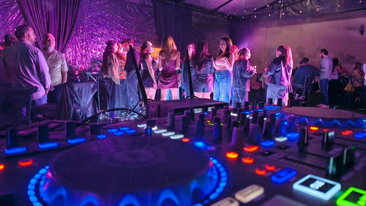 Grupo de invitados de pie frente a la cabina con iluminación de color